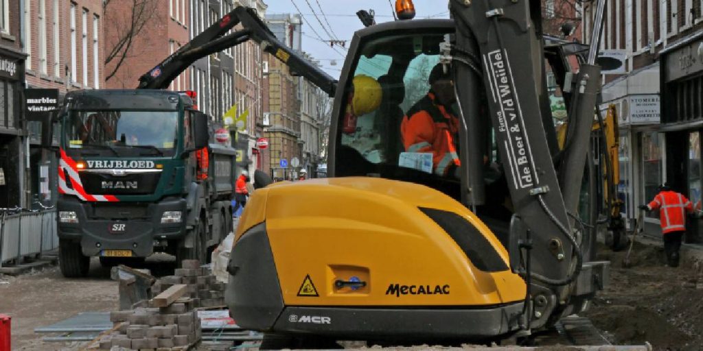 An excavator in the process of diligently removing debris from a construction site.