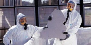 Two asbestos testers examining an asbestos tile to estimate asbestos renovation cost.

