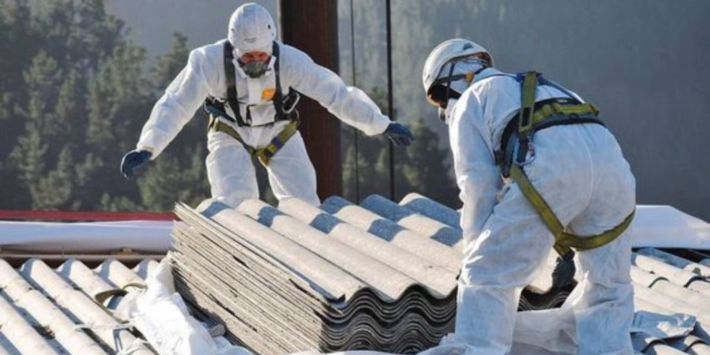 Team removing asbestos, a crucial step influencing the cost of demolishing a house