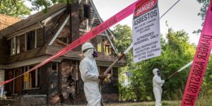 rained asbestos removal expert carefully removing asbestos from a roof to ensure a hazard-free environment."