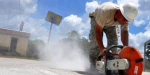Skilled demolition worker breaking concrete with a powerful saw