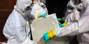 "Professional asbestos remover in protective gear safely disposing of asbestos materials, following health and safety regulations
