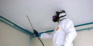 Asbestos Certification worker in protective gear safely removing asbestos materials