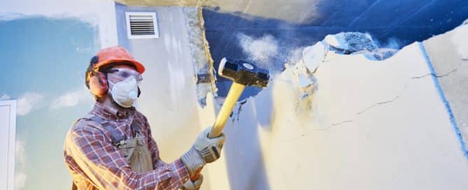 Worker With Sledgehammer At Indoor Wall Destroying